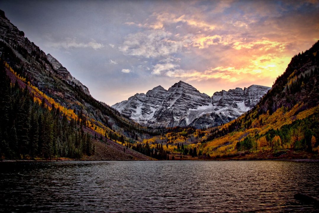 A mountain peak reflected in an alpine lake surrounded by aspens