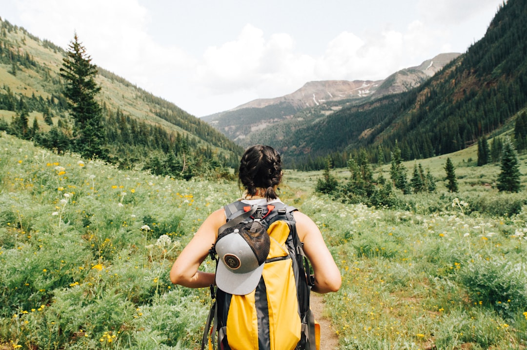Une voyageuse avec un sac à dos marche seule au milieu d'une végétation luxuriante