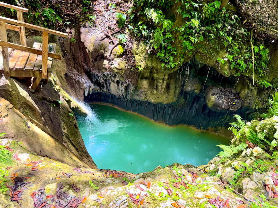 A turquoise pool with a waterfall tumbling over rocks