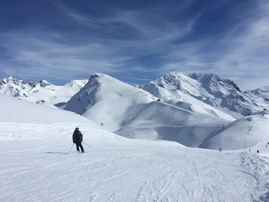 Skieur dévalant une piste enneigée dans les Alpes françaises