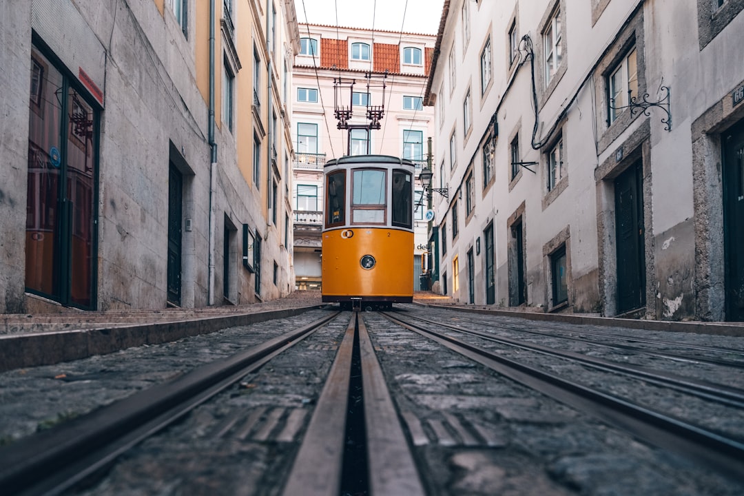Un tramway jaune dans une rue étroite de Lisbonne