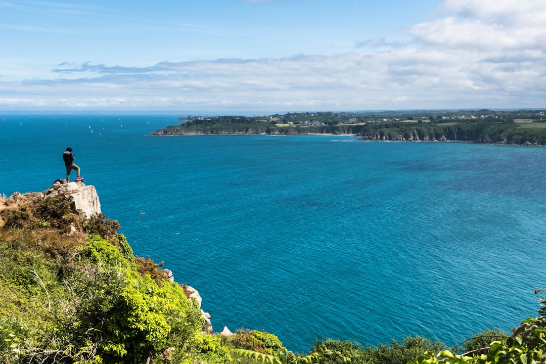 Randonneur au bord des falaises côtières face à l'océan