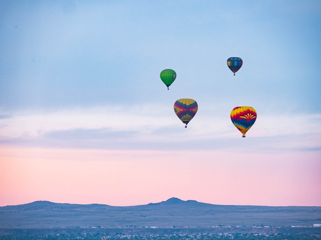 A group of hot air balloons flying in the morning sky